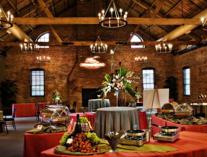 The brick interiors of the Cork Factory Hotel with hanging chandeliers and banquet tables.